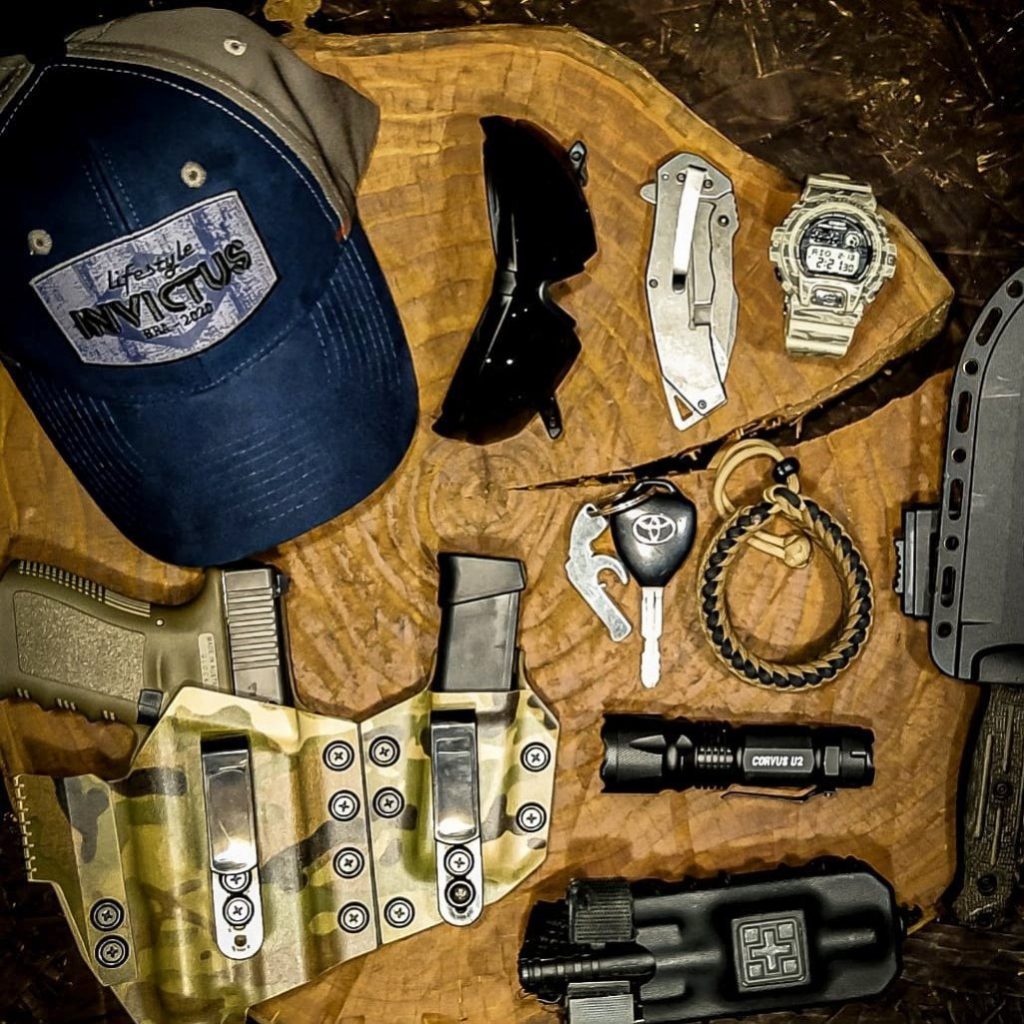 EDC com laterna, arma, canivete, boné, paracord e carregador, entre outros.